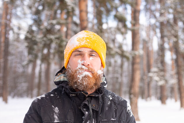 成人一个留着胡子的成年男子在冬天的森林里 脸都冻在雪里 不高兴地冻着紧张旅行健康