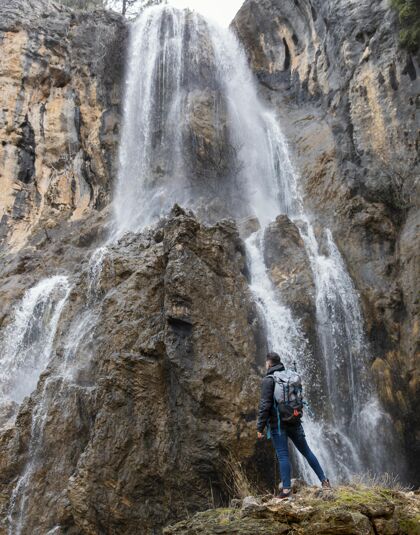 年轻瀑布里的自然人冒险男性徒步旅行