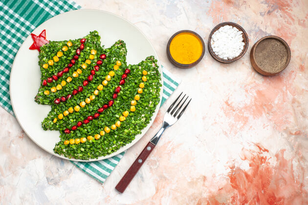 年顶视图美味的蔬菜沙拉在新年树形状与调味品在一个轻背景形状背景光