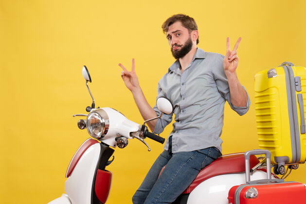 成人旅游概念与年轻的情感胡须男子坐在摩托车上作出黄色的胜利姿态年轻人自行车制造