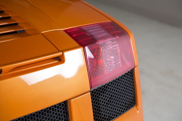 新特写镜头背光的现代橙色汽车司机闪亮速度