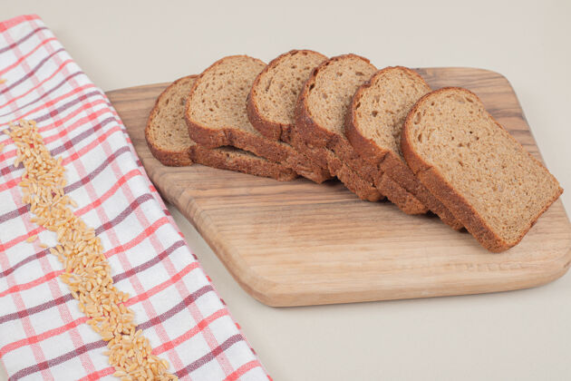 营养把新鲜的棕色面包片放在木板上谷类面包房食品