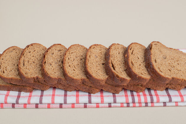 切片把新鲜的棕色面包片放在桌布上脆营养美食
