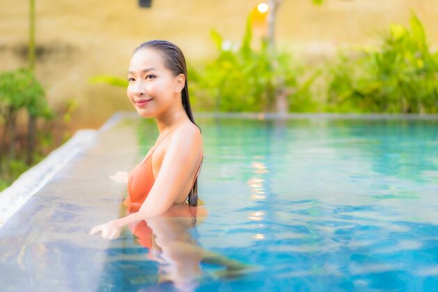 甲板美丽的亚洲年轻女子在游泳池旁尽情放松 享受休闲度假家具水椅子