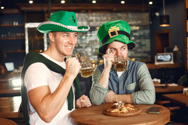 问候戴绿帽子的男人朋友们庆祝圣帕特里克节在酒吧庆祝圣帕特里克圣帕特里克日男性