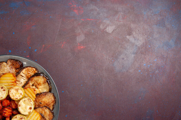 肉顶视图烤蔬菜土豆和茄子在黑暗的空间盘子里烘焙生的顶部