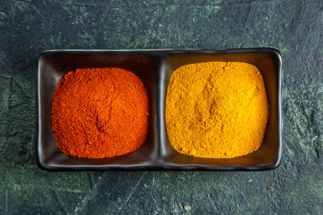 颜色在混合颜色的表面上用红辣椒和黄姜做成的香料碗的特写镜头 有自由空间混合甜瓜胡椒
