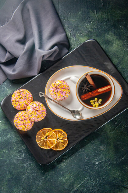 茶杯在黑暗的背景下 在盘子和托盘里放上一杯茶和小甜饼干晚餐甜点深色