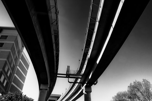 金属白天阳光下混凝土桥的低角度灰阶透视单色现代