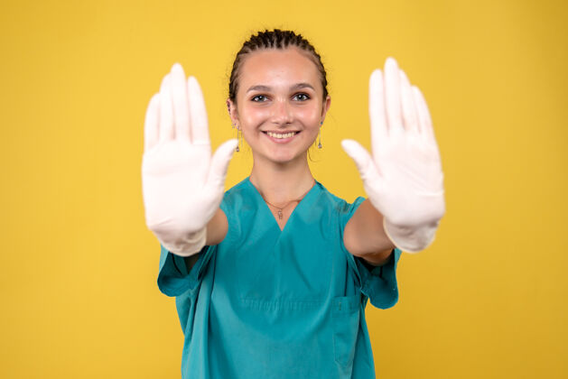 肖像黄墙上戴着特制手套的女医生正面图人戴手套