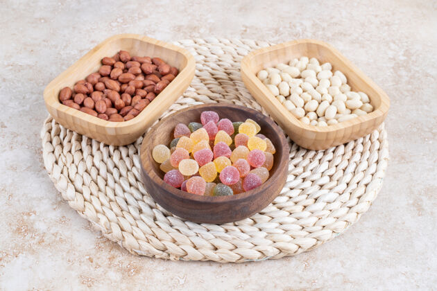 糖果在大理石表面放上一碗装糖果和花生仁的木碗花生坚果甜点