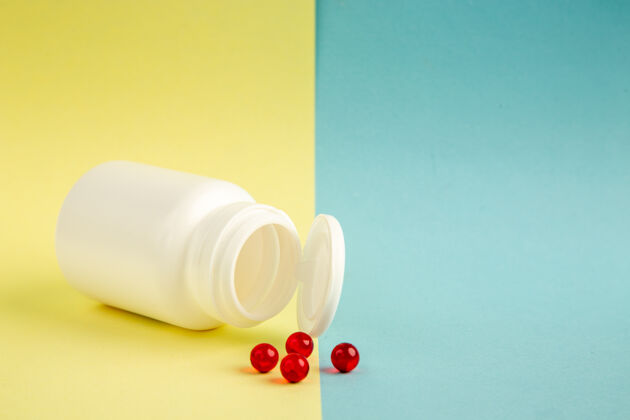 处方药前视图白色塑料罐 黄色蓝色背景上有红色药丸红色科学前面