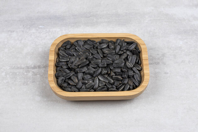 健康装满向日葵黑籽的木板放在石桌上向日葵食品营养