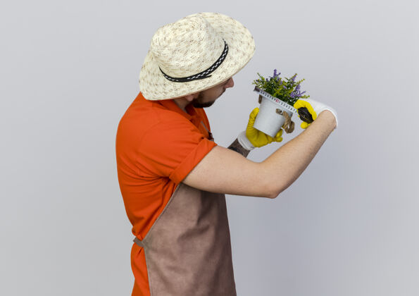 空间自信的男园丁戴着园艺帽 用卷尺量着花盆信心花园复制