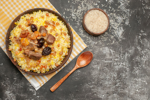 菜肴顶部特写镜头：米饭勺一碗开胃的米饭放在格子桌布上小吃胡椒粉橄榄