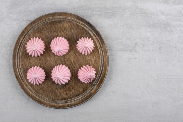 卡路里粉红色的蛋白酥皮放在木板上 放在大理石桌上烘焙配料甜点