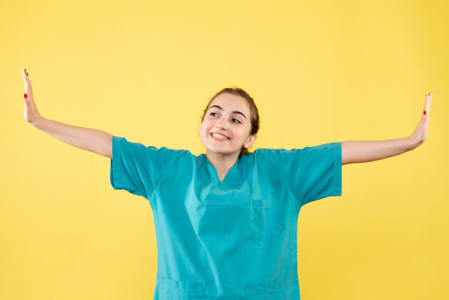健康黄墙上年轻女医生穿着医用衬衫的正面图正面人快乐