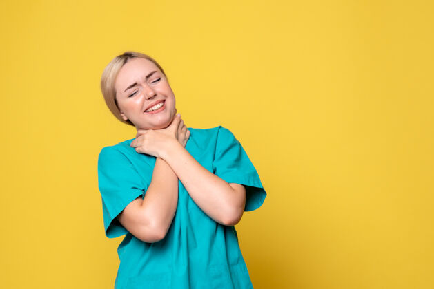 衬衫黄墙上年轻女医生身穿医用衬衫喉咙痛的正面图前面美丽痛苦
