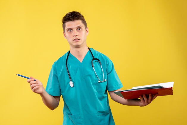 西装前视图中的男医生在一个黄色的墙上拿着分析医疗服医生医疗前面