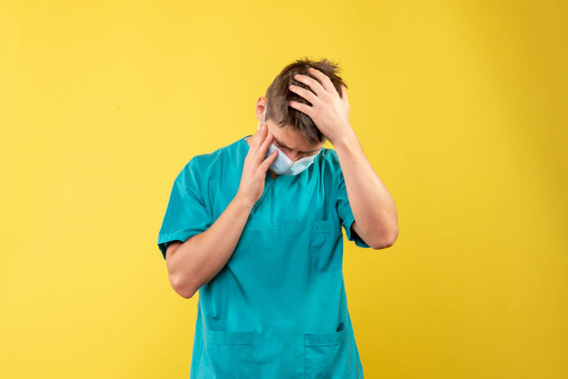 人黄墙上的男医生穿着医疗服 戴着无菌口罩病毒健康正面