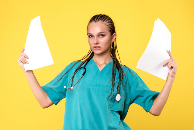 病毒身着医疗服的女医生的正面图 黄色的墙上有纸听诊器西装健康