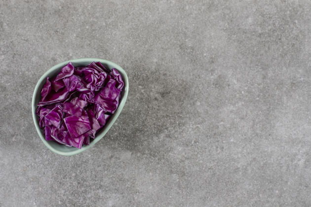 蔬菜把红卷心菜切成片放在碗里 放在大理石桌上新鲜成熟的碗