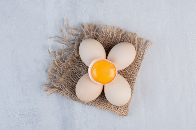 生的一捆鸡蛋和蛋黄放在大理石桌上早餐有机味道