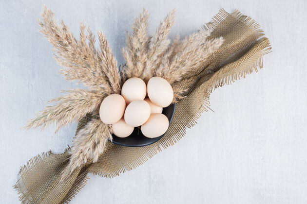 美味一碗鸡蛋 一块布和羽毛草在大理石桌上生的鸡蛋营养