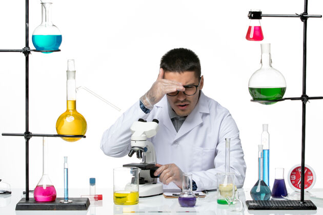 书桌白衣男化学家在白色办公桌上用显微镜观察病毒冠状病毒-疾病科学使用成人疾病