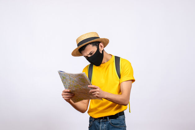 黄色正面图：戴着面具和黄色t恤的年轻人在看地图工作成人人