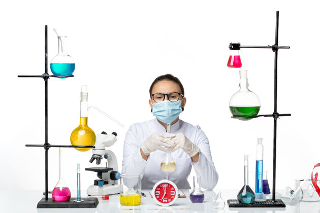 溶液前视图：穿着白色医疗服的女化学家 在白色背景上戴着口罩保持溶液化学家病毒冠状病毒-飞溅实验室液体实验室化学家