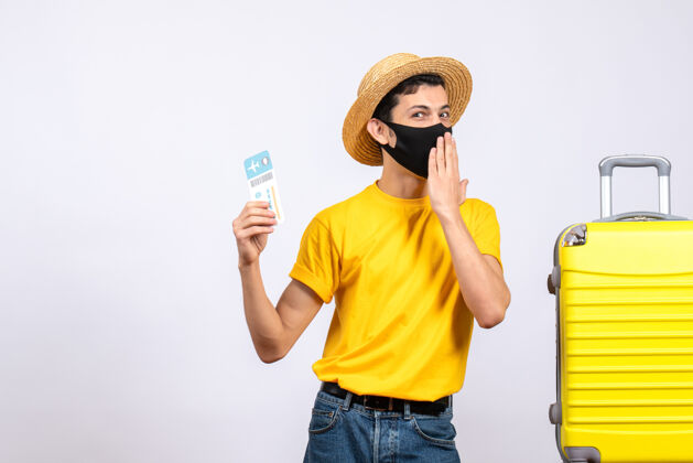 旅行正面图身着黄色t恤的快乐游客站在黄色手提箱旁举着旅行票票向上T恤