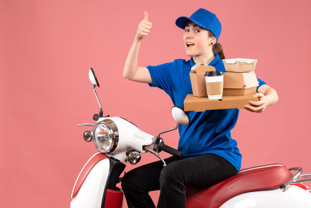 正面正面图女性快递员与食品包装盒上粉红色的工作颜色工人食品送货自行车服务快乐微笑视图