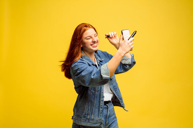 手黄色背景上的白人女性肖像美丽的女性红发模特人类情感的概念 面部表情商业追随者人