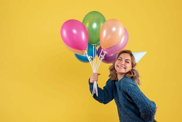 空气正面图：带着彩色气球的年轻女性年聚会五颜六色