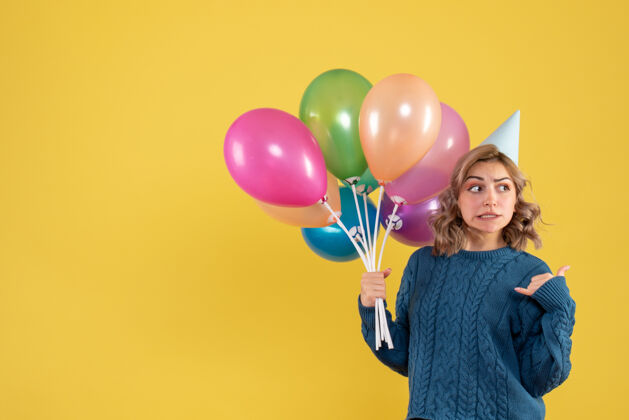颜色正面图：带着彩色气球的年轻女性聚会气球女人