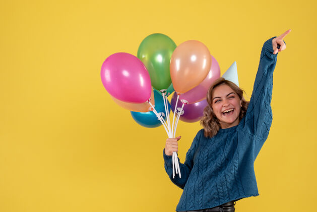 庆祝正面图：带着彩色气球的年轻女性圣诞节假日年轻女性