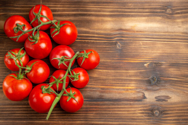素食在棕色的木桌上俯瞰红色的西红柿和成熟的蔬菜饮食成熟西红柿