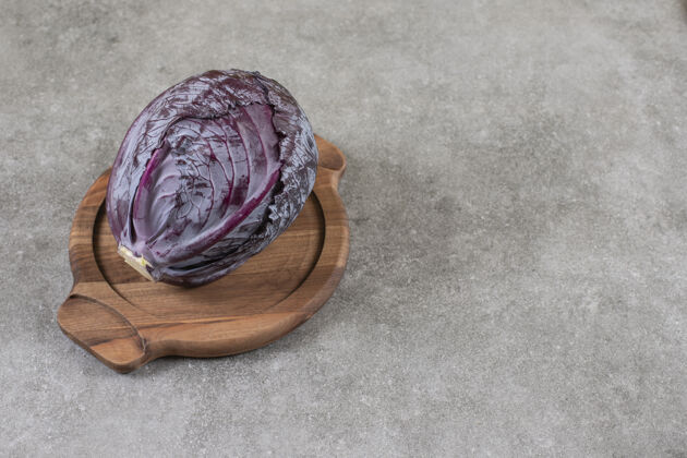 农业把红卷心菜切成片放在木板上 放在大理石桌上生的成熟的蔬菜