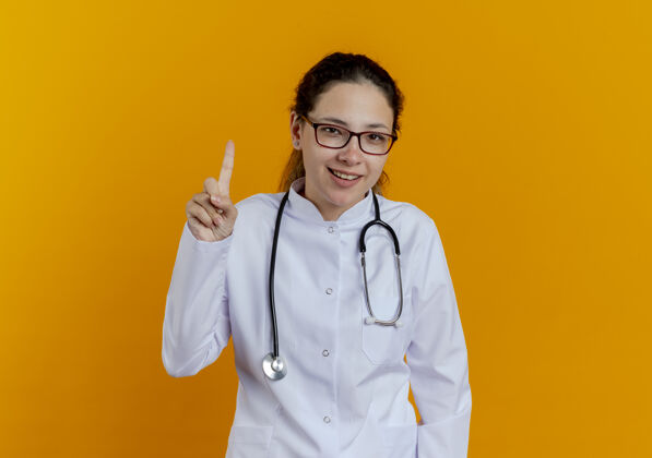 医生印象深刻的年轻女医生穿着医用长袍和听诊器戴着眼镜点了起来医学眼镜成人