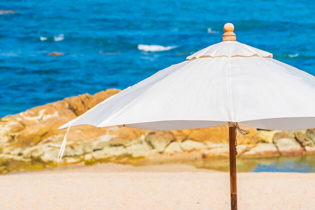 巡航美丽的热带海滩 带着雨伞和椅子 环绕着白云和蓝天 适合度假旅行沙滩海洋海岸