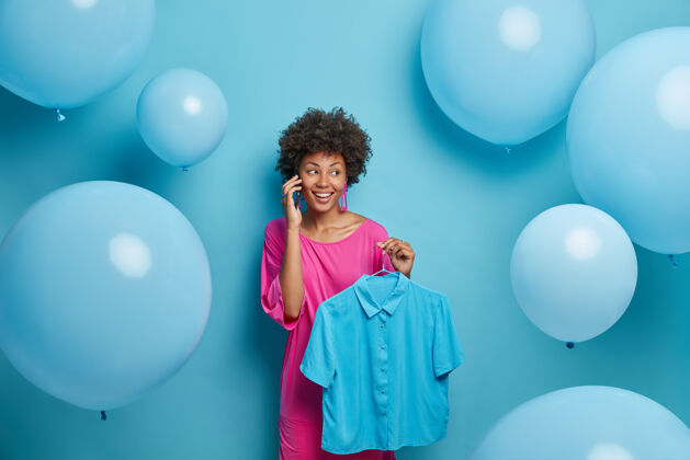风格快乐时尚的女人和朋友通电话 把蓝色的时尚衬衫挂在衣架上 在母鸡聚会上穿上衣服 讲述最后一次在服装店买衣服的事人 风格 服装和庆祝年轻衣架节日