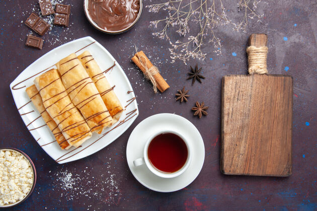 甜点俯瞰美味的巧克力甜点和一杯茶在黑暗的地板上甜烤饼干甜点糖蛋糕巧克力美味糕点