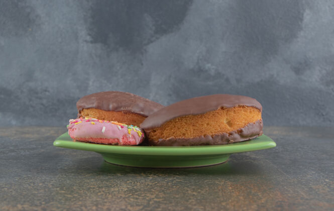 甜点把甜甜圈和巧克力蛋糕放在盘子里巧克力釉料美味