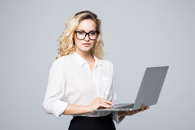 态度一位年轻快乐的女商人的肖像 在白墙上挂着一台笔记本电脑商务女性年轻手