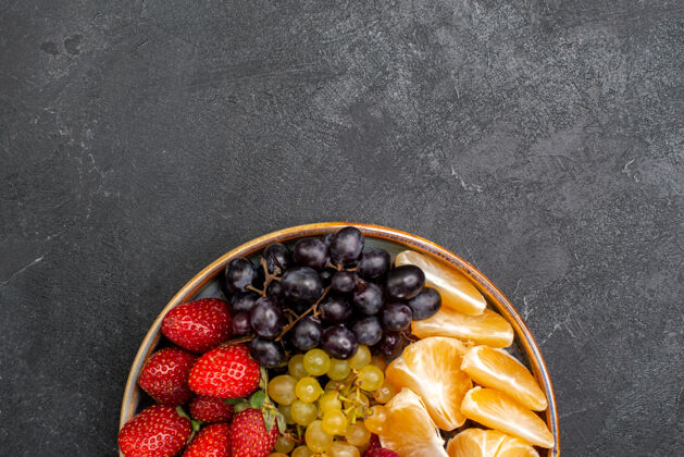 浆果顶视图水果成分草莓葡萄覆盆子和橘子托盘内黑暗的空间橄榄新鲜异国情调