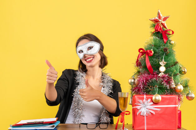 手势新年气氛 迷人的女士穿着西装戴着口罩在办公室做ok手势穿着可以心情