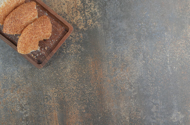 美味把切成薄片的百吉饼捆在毛巾上的木板上 小吃百吉饼芝麻
