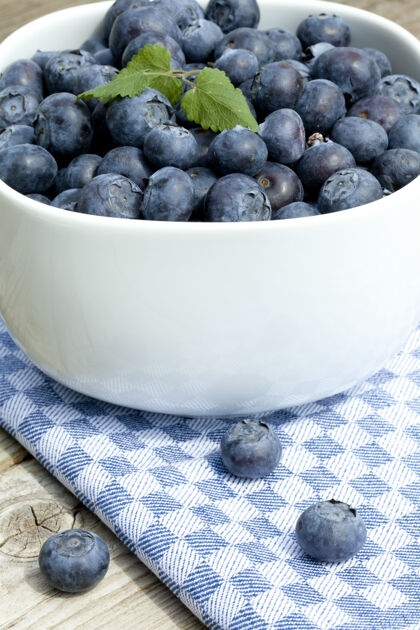 水果垂直特写新鲜蓝莓在一个白色的碗格子饮食叶子