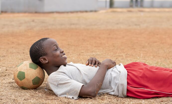 玩一个拿着足球的非洲小孩足球足球比赛孩子